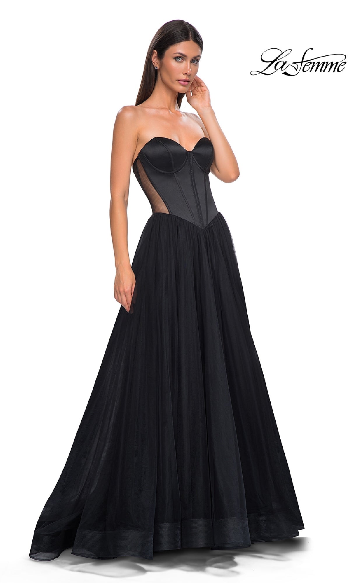 A woman stands against a white background wearing the La Femme 32771 Black Strapless Long Prom Dress, featuring a sweetheart neckline, structured bodice, and sheer side panels.